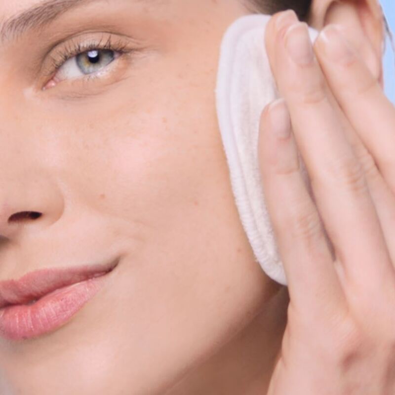Mujer limpiándose la piel con agua micelar