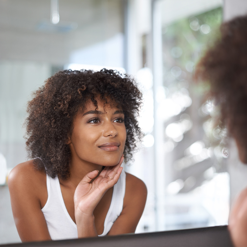 Mujer en el espejo con manchas oscuras