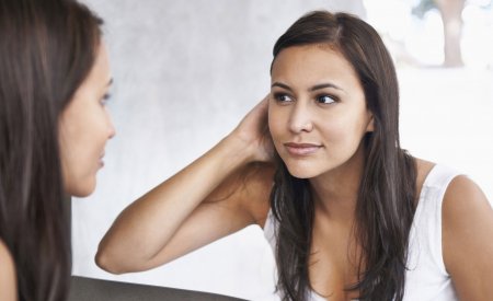 Woman checking her skin in the mirror