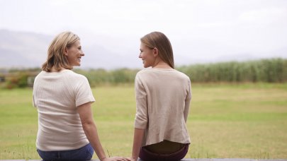 Madre e hija sentadas y juntas