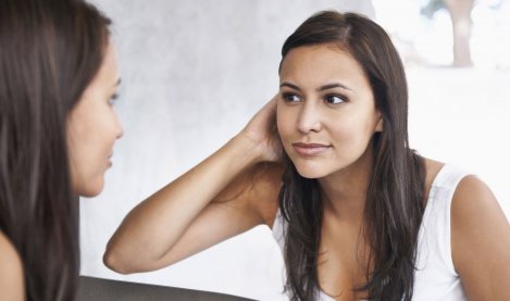 Woman checking her skin in the mirror